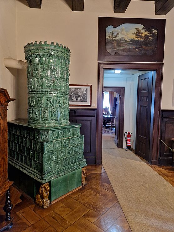 Grüner Kachelofen auf Burg Kriebstein mit Einhorndarstellung auf einer der Kacheln