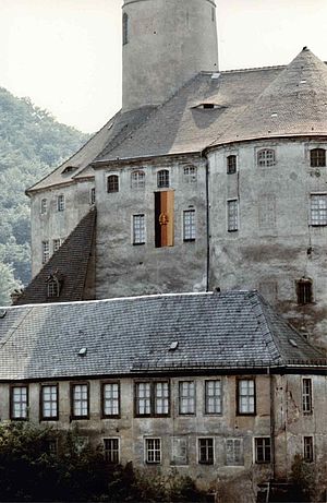 Eine DDR-Fahne hängt an der sichtlich maroden Fassade Schloss Weesensteins