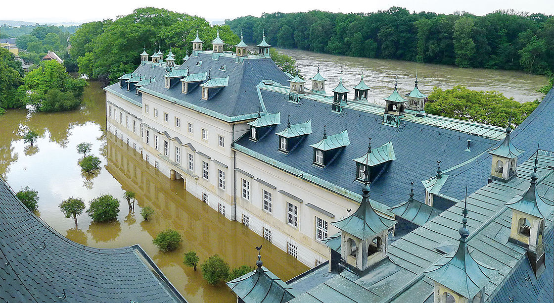 Foto des Schlosses, vom Dach aus fotografiert. Das Erdgeschoss des Schlosses steht unter Wasser von den Fliederbäumen im Hof sind nur noch die Spitzen zu sehen.